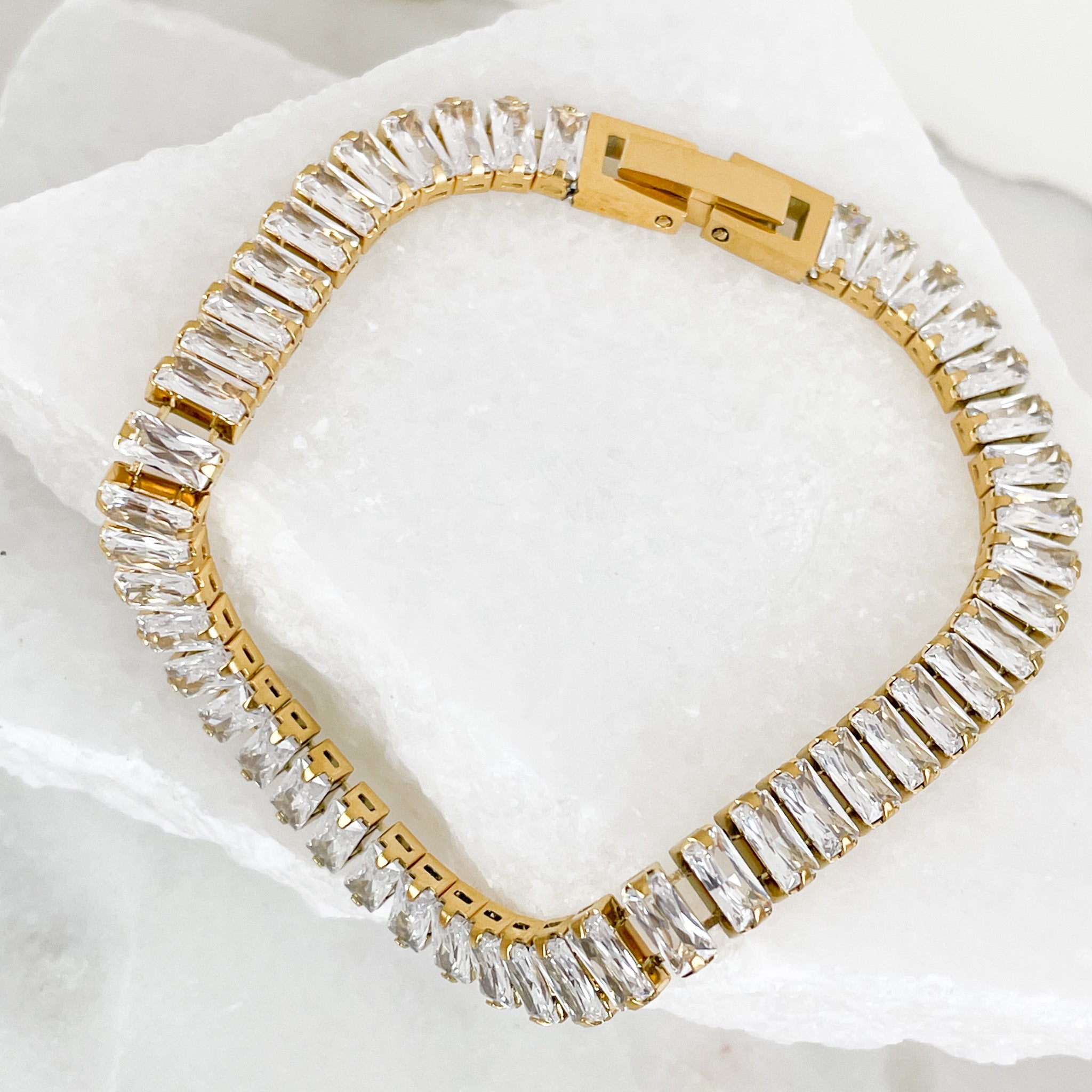 Baguette-cut cubic zirconia brings glamorous sparkle to an elegant tennis bracelet finished in 18K PVD Gold Plated