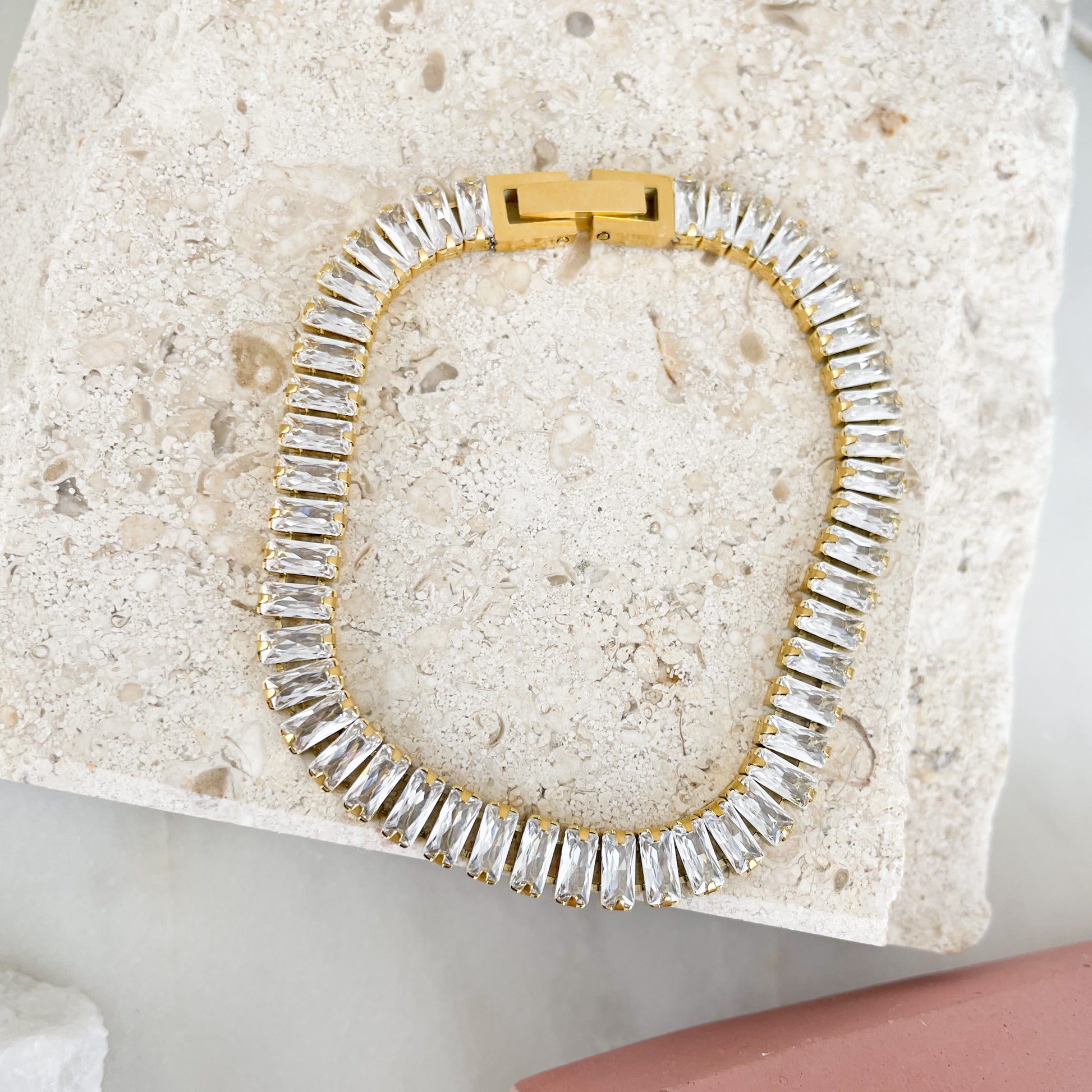 Baguette-cut cubic zirconia brings glamorous sparkle to an elegant tennis bracelet finished in 18K PVD Gold Plated