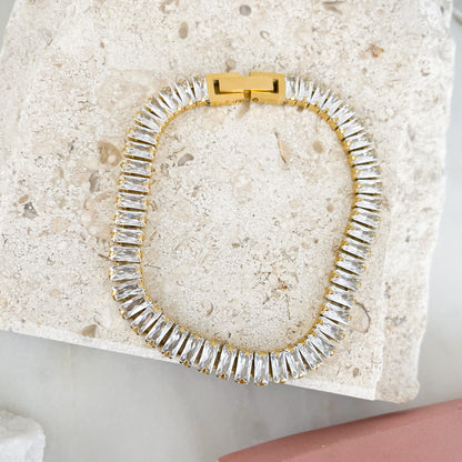 Baguette-cut cubic zirconia brings glamorous sparkle to an elegant tennis bracelet finished in 18K PVD Gold Plated